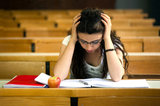 young beautiful woman studying lesson in the lecture hall, worried expressive portrait with vivid bright colors