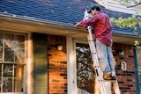 Man Cleaning Gutters on a Ladder Against a Brick House Roof Gutter Cleaning Melbourne PO Box 481 East Melbourne VIC 3002 