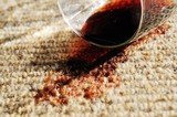 A glass of red wine spilt on a pure wool carpet.
