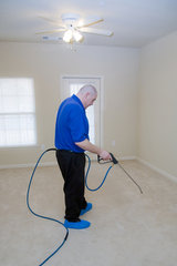 Man cleaning carpet with commercial cleaning equipment