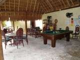 The communal area, pool table, TV, games, darts, tables, all under the palapa roof,