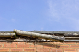 A broken plastic gutter on the roof of a house, Cypress Water Fire Smoke Damage Restoration Services, Cypress