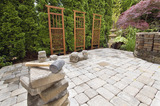 Stack of Brick Pavers for Hardscape in Backyard Landscaping with Trellis and Trees