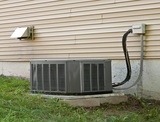 A residential central air conditioning unit sitting outside a home.