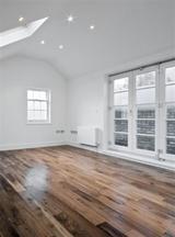 empty unfurnished loft room with roof window and solid wood floor