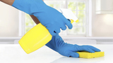 hand with glove using cleaning sponge to clean up