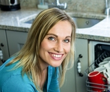 Pretty blonde woman emptying the dishwasher in the kitchen, Sparks Appliance Repair Pros, Sparks