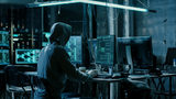 Hooded Hacker Using His Comuter with Different Information to Break into Corporate Data Servers and Infects them with Virus. His Hideout Place has Dark Atmosphere, Multiple Displays, Cables Everywhere.