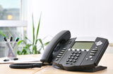 Advanced managerial VoIP phone on beech desk.