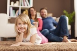 Portrait of smiling girl relaxing with her parents at home 